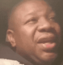 a close up of a man 's face with his mouth open and his eyes closed .