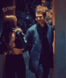 a man and a woman are standing in front of a door with the word fayam on the bottom
