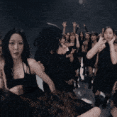 a group of girls in black dresses are dancing together