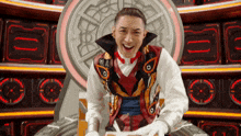 a man in a clown costume is sitting on a throne
