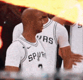 a man in a spurs jersey stands in front of his team