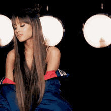 a woman with long hair is wearing a blue jacket and red gloves .