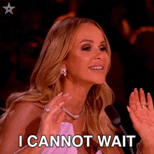 a woman says " i cannot wait " while sitting in front of a microphone