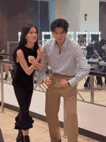 a man and a woman are standing next to each other in a room