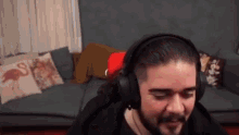 a man wearing headphones is sitting on a couch .