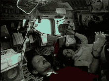 a man and a woman are laying in the cockpit of a space ship .