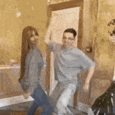 a man and a woman are dancing together in a hallway .