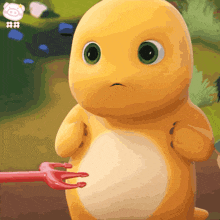 a stuffed animal with green eyes is being held by a pink fork