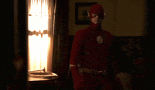 a man in a flash costume is in a dark room