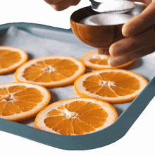 adding sugar on top of sliced orange two plaid aprons sprinkle sugar adding flavor preparing food