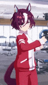 a girl in a red jacket with a white stripe on the sleeves is standing in a gym
