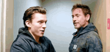 tony stark and peter parker are standing next to each other in an elevator .