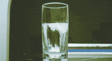 a glass of water sits on a table