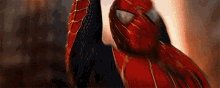 a close up of a person in a spiderman costume holding up their hand .