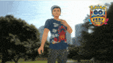 a man wearing a shirt that says pokemon go fest on it