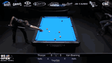 a pool table with a blue cloth and a man holding a cue