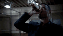 a man in a suit is drinking from a glass
