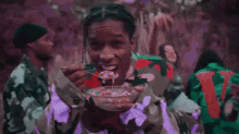 a man in a camouflage jacket is eating ice cream with a spoon .