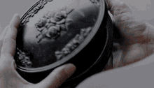 a close up of a person holding a black object that says ' abercrombie ' on it