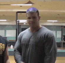 a man wearing a grey shirt that says ' muscletech ' on it
