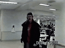 a man walking in a hallway with the date dec 9 1998 on the bottom