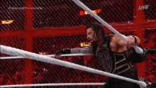 a man is standing in a wrestling ring with a rope around his head .