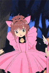 a little girl in a pink dress with cat ears