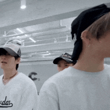 a man wearing a white shirt that says jordan is standing next to another man wearing a black hat