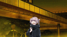 a girl in a black coat is laughing in front of a building