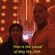 a man and a woman standing next to each other with the words that is the sound of may the 24th in yellow letters
