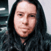 a man with long hair and a beard wearing a hooded jacket
