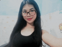a woman wearing glasses and a black tank top