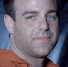 a close up of a man 's face with a beard and blue eyes .