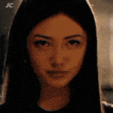 a close up of a woman 's face with the letters jc on the bottom