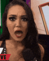 a woman is talking into a microphone with the word live in red behind her
