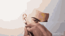 a man is drawing a picture of a man 's face with a pen .