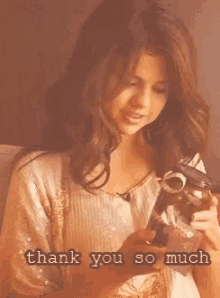 a woman is holding a camera with the words thank you so much written below her