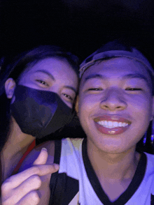 a man and a woman wearing masks pose for a photo