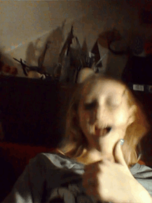 a blurry picture of a woman 's face with a sticker on her shirt that says ' a '