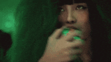 a woman is singing into a microphone in a dark room .