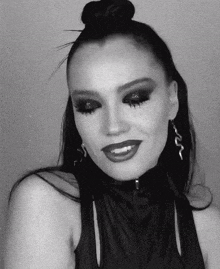 a black and white photo of a woman wearing earrings