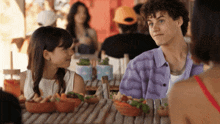a boy and a girl sit at a table with bowls of food on it