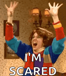 a woman is screaming with her arms in the air and the words i 'm scared above her