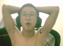 a shirtless man wearing glasses and headphones