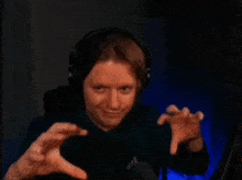 a woman wearing headphones is making a funny face with her hands outstretched .
