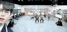 a group of people are sitting and standing in a classroom ..