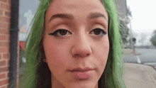 a woman with green hair is making a face