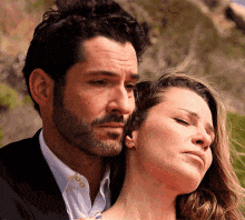 a man and a woman are hugging each other with their eyes closed