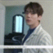 a blurred image of a man in a lab coat standing in front of a mirror