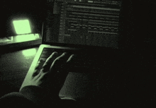 a person is typing on a laptop computer with a green screen